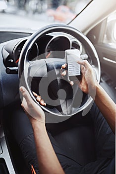 Danger, texting and driving with hands of person on steering wheel with scroll, phone and risk. Road safety, awareness