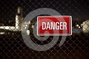 Danger warning sign hanging on a fence guarding private