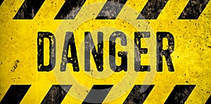 DANGER warning sign word text as stencil with yellow and black stripes painted over concrete wall danger background