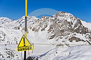 Danger yellow sign, snowy mountain