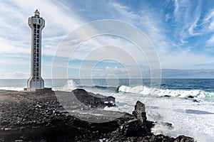 Dangerious ocean stormy waves hits black lava rocks by Faro de las Hoyas, La Palma island, Canary, Spain