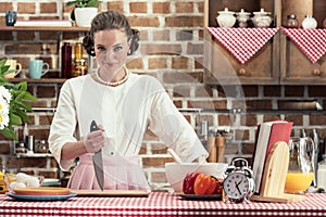 dangerous adult housewife with knife looking at camera