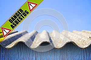 Dangerous asbestos roof - one of the most dangerous materials in buildings - concept image with danger asbestos text written on a