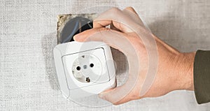 Dangerous bad,broken socket,plug in bathroom,falling out of wall. Outlet installation in old apartment. Poor electrical