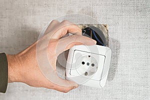 Dangerous bad,broken socket,plug in bathroom,falling out of wall. Outlet installation in old apartment. Poor electrical