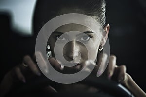 Dangerous beauty woman driving a car, close up portrait