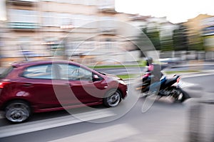 Dangerous city traffic situation with a motorcyclist and a car