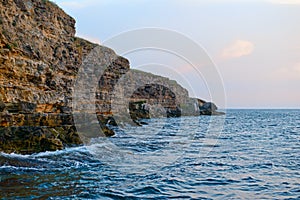 Dangerous cliffs on the seashore on a summer evening