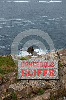 Dangerous cliffs sign in red writing