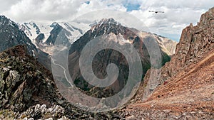 Dangerous couloir. Panoramic colorful sunny green landscape with silhouettes of big rocky mountains and epic deep gorge.