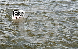 'Dangerous Currents' sign in flooded river