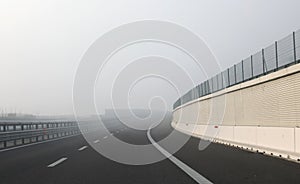 Dangerous curve of the desert highway with dense fog