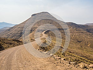 Dangerous and curvy mountain dirt road with steep drop to the valley, Lesotho, Southern Africa