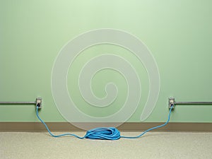 Dangerous use of  blue coiled extension cord plugged into two outlets simultaneously photo
