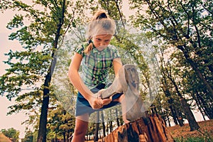 Dangerous and formidable girl chopping wood with an ax and looking angrily into the camera