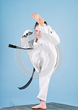 She is dangerous. Girl little child in white kimono with belt. Karate fighter ready to fight. Karate sport concept. Self