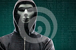 Dangerous hacker over abstract digital background with binary code. Obscured dark face in mask and hood. Data thief