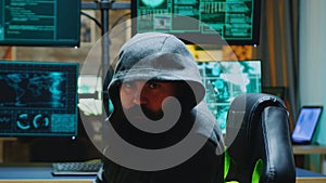 Dangerous hacker wearing a hoodies and looking into the camera