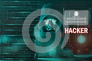 Dangerous Hooded hacker man using laptop with binary code digital interface