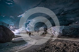 Dangerous ice cave vault with huge cracks in the ceiling