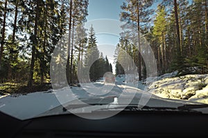 Dangerous icy and snowy road in Sweden, following another car through the forest danegrous and hazardous situation