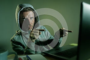 Dangerous looking hacker man in hoodie hacking internet computer