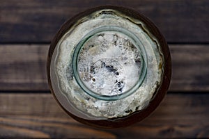 Dangerous mold in a glass jar with sweet drink, closeup, top view. Mold is very dangerous to health. Virus particles, fungus in