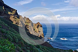 Dangerous mountain road on the background of the ocean. Landscape in a mountainous area near the edge of the island