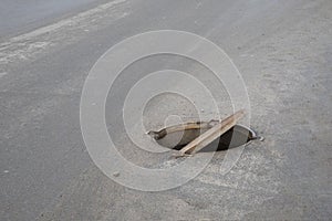 Dangerous opened manhole cover, opened sewerage hatch it the middle of the road