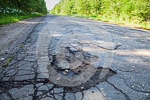 Dangerous pothole in the asphalt rural road. Road damage