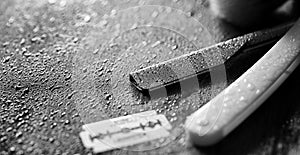 A dangerous razor and a metal blade on the table. Men`s shaving