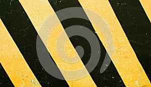 Dangerous road sign. Black and yellow stripes on concrete block texture.