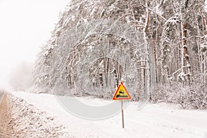 Dangerous road in winter with a sign