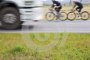 Dangerous roads for sports cyclists - motion concept with cyclists and trucks