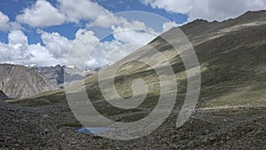 Dangerous and rugged mountain road under the blue sky and white clouds