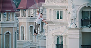 Dangerous sport, man is slacklining between buildings, swaying rope, Turkey, 4k