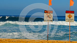 Dangerous surf conditions and a no swimming sign on the beach