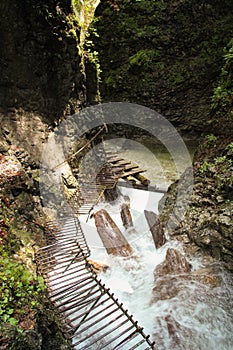 Nebezpečná stezka přes vodopád s dřevěnými žebříky v národním parku Slovenský ráj, Slovensko