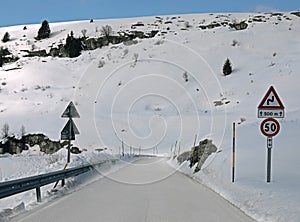 dangerous very slippery mountain road with ice sheet after snowfall in winter