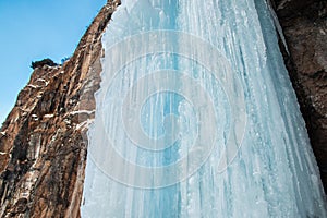 Dangerous waterfall frozen in winter on a rocky mountain