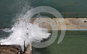 Dangerous waves breaking over rock pool