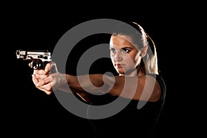 Dangerous woman terrorist dressed in black with a gun in her han