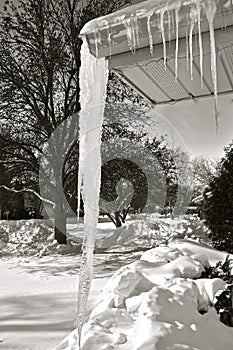 Dangerously huge icicle hanging from an eavestrough photo