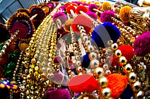 Dangling golden decorations with bells and puffs hanging in a store in chandni chowk delhi