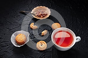 Danish butter cookies with a cup of tea on a black slate background photo