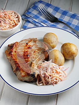 Danish dinner with grilled pork, boiled potato, and cole slaw