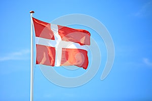 Danish flag with blue sky on background photo