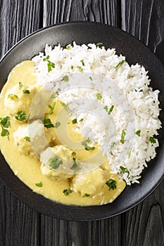 Danish Meatballs In Curry Boller i Karry close up in the plate. Vertical top view photo