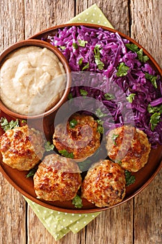 Danish meatballs frikadeller served with stewed red cabbage garnish close-up in a plate. vertical top view