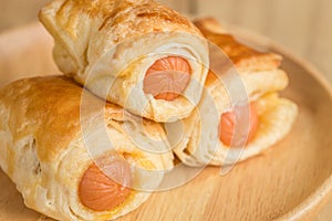 Danish Pastry with sausage on wooden dish